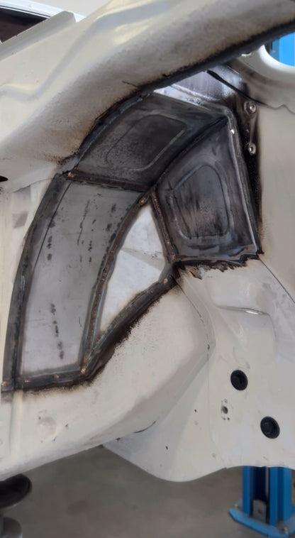 Bead-rolled IMR front tub panels welded into the Mazda RX3 wheel arch, seen from the wheel well
