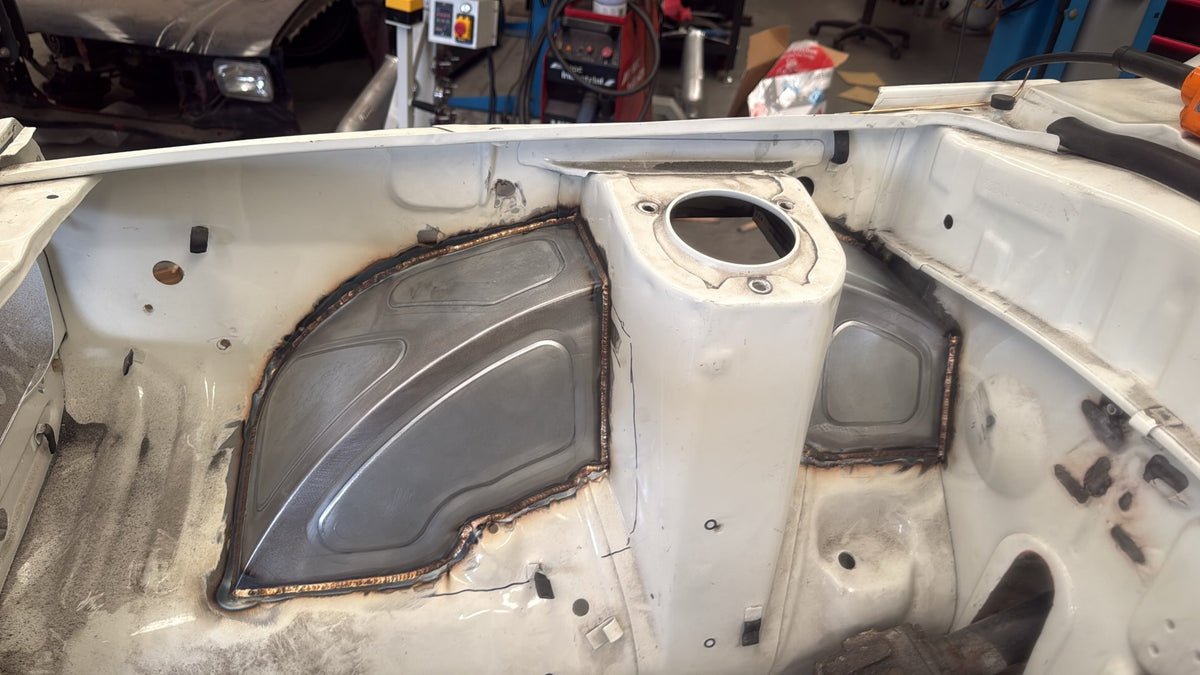 IMR bead-rolled front tubs welded into a Mazda RX3 engine bay either side of the strut tower